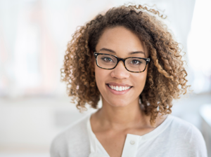 Black happy female wearing glasses with a big smile against a white background